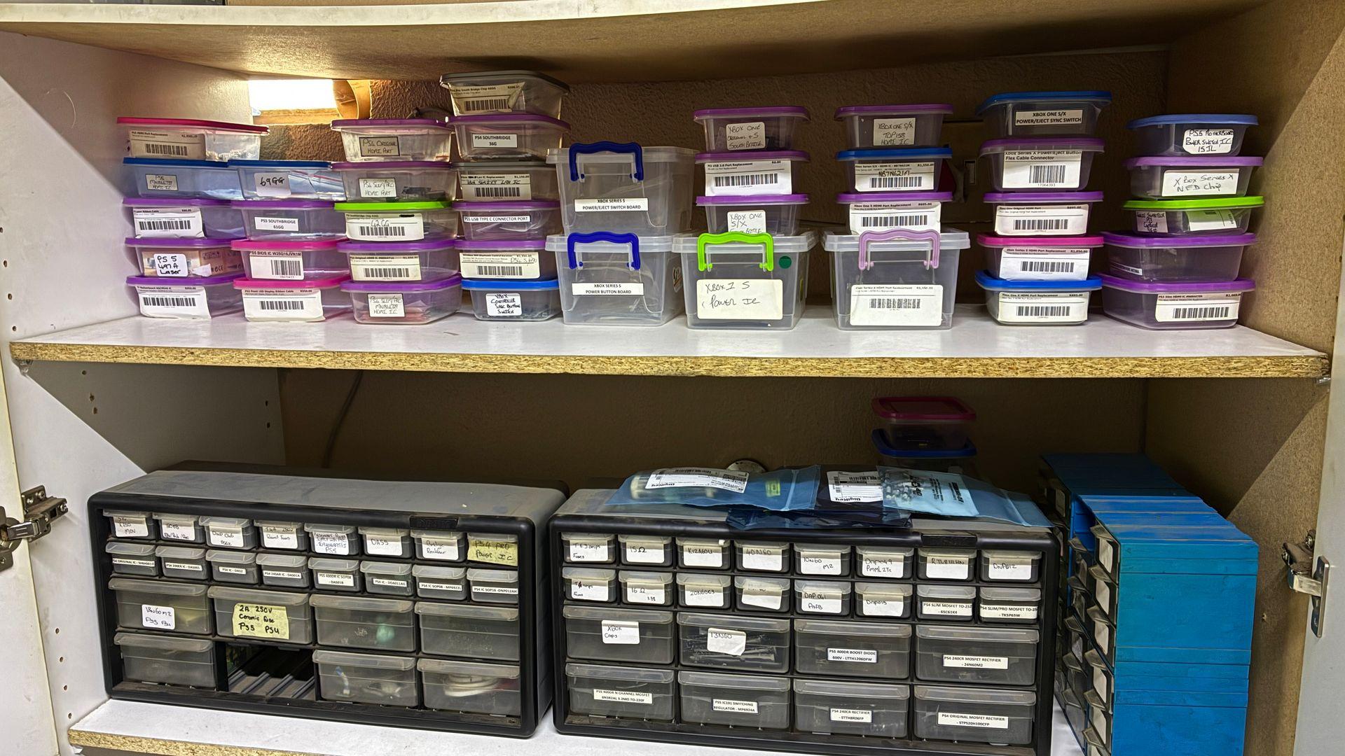 Organised and labelled PlayStation and Xbox repair parts storage with component drawers at Console Service Centre