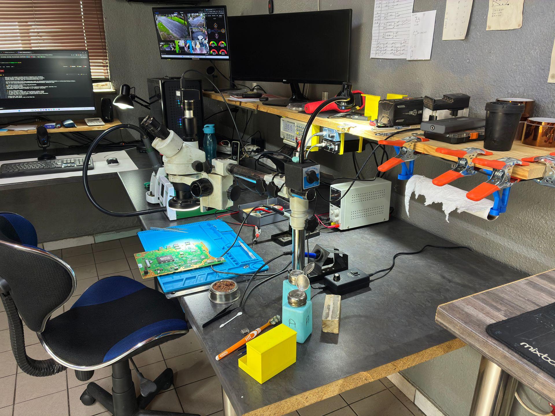 Professional soldering and microscope station with circuit board and 3D-printed tool holders for PlayStation and Xbox repairs